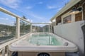 Sink into the bubbling waters of your private hot tub and let your cares melt away as you soak in sweeping lake and mountain views through the wraparound glass enclosure.