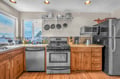 Your fully equipped kitchen features modern appliances and granite counters, perfect for preparing meals while enjoying scenic views through large windows.