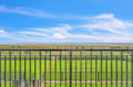 Stunning oceanfront balcony overlooking pristine beach and rolling dunes under endless blue skies.