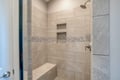 Step into your beautifully tiled walk-in shower with mosaic accents, built-in bench, and dual storage niches for ultimate relaxation.