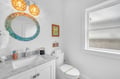 Refresh in your bright coastal bathroom with marble counters and charming pendant lights.