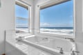 Soak in your private tub while waves crash just outside your window—pure oceanfront bliss awaits.