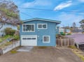 Charming coastal home with bright blue siding and convenient parking awaits your arrival in this peaceful neighborhood.