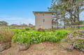 Modern three-story property set on spacious grounds with lush landscaped gardens, native trees, and colorful plantings providing a peaceful retreat in a rural setting.