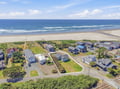 Coastal property offering direct beach access in a peaceful neighborhood, with expansive sandy shores and ocean waves just steps from the door.