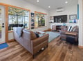 Relax in your stylish living room with leather seating, while enjoying lake views through expansive windows.