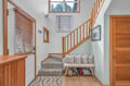 Settle into your cozy reading nook beneath the staircase, where soft cushions and warm wood details create the perfect spot to unwind.