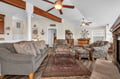 Relax in your charming living space with exposed wooden beams, nautical touches, and comfortable seating around the warm fireplace.