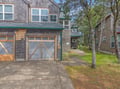 Charming cedar-shingled townhome with convenient garage parking amid peaceful wooded surroundings in a quiet residential setting.