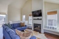 Sink into plush seating and enjoy the warmth of your private fireplace beneath the mounted TV. Natural light fills this airy living space, perfect for cozy evenings.