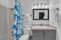 Step into a bright, spotlessly clean bathroom where crisp white towels and refreshing coastal touches await. The modern fixtures and cheerful blue accents create a welcoming retreat for your getaway.