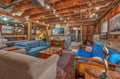 Unwind in your rustic basement retreat with exposed beams, cozy seating, and warm lighting creating the perfect atmosphere for relaxation.