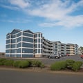 Charming multi-story building with attractive blue siding and ample guest parking in a scenic seaside location, conveniently situated for easy arrival and departure.