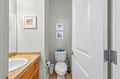 Your private bathroom features a clean, modern design with elegant coastal artwork and thoughtful amenities for your comfort.