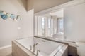 Unwind in your luxurious soaking tub with serene views through French doors to your private balcony beyond.