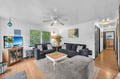 Relax in your spacious living room with plush sofas, a large TV, and cool ceiling fan. Bright windows and coastal décor set the stage for your perfect getaway.