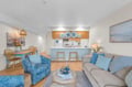 Sink into coastal comfort with ocean-inspired blues, cozy seating, and your fully equipped kitchen for memorable seaside getaways.