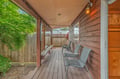 This covered porch offers a peaceful spot to relax with comfortable seating and gentle natural light filtering through the trees, creating a serene escape just steps from your door.