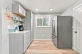 Step into your well-appointed kitchen, where sleek stainless steel appliances, bright white cabinetry, and warm wood-style floors create an inviting space for preparing your favorite meals.