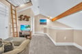 Your own cozy loft retreat with exposed beams, skylight, and entertainment setup for perfect relaxation.