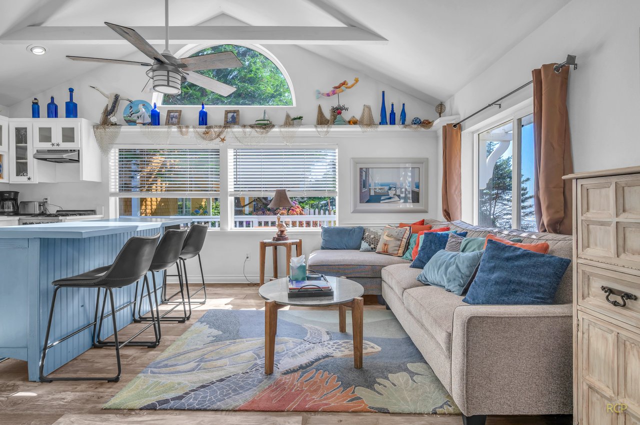 Relax in your bright, airy living space with vaulted ceilings, coastal decor, and colorful pillows inviting you to unwind.