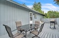 Your private deck awaits with dining space and BBQ grill, perfect for cooking out and enjoying meals under open skies surrounded by trees.