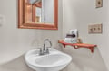 Your private half-bath features warm wood accents, fresh towels, and thoughtful touches that make every moment feel comfortable and welcoming.