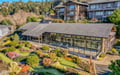 Stunning modern architectural retreat with expansive glass walls and professionally landscaped gardens in an upscale hillside neighborhood.