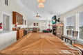 Relax in your open-concept living space with cozy fireplace, modern kitchen, and dining area perfect for memorable meals together.
