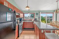 Your fully equipped kitchen with warm wood cabinets and granite counters awaits your culinary adventures, complete with garden views.