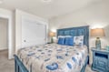 Your peaceful coastal bedroom features a charming blue headboard and sea-inspired linens, creating the perfect retreat after your beach adventures.