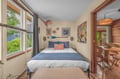 Drift off in this cozy bedroom adorned with coastal art and soft blue linens. Natural light fills the room, while warm wood accents create a welcoming retreat after a day of exploring.