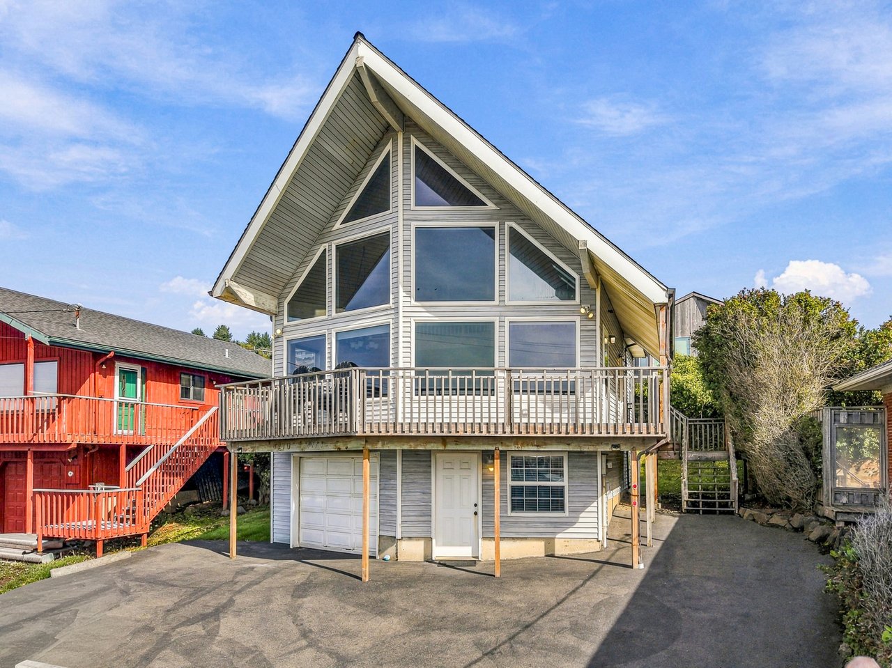 This distinctive A-frame vacation home features dramatic windows and a spacious balcony, located in a quiet residential neighborhood. The property includes parking and seasonal outdoor space for your stay.