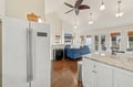 Bright open-concept space with vaulted ceilings and abundant natural light. Kitchen flows seamlessly into the living area, with water views through expansive windows and access to your private deck.