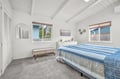 Drift off to sleep in your serene coastal bedroom with exposed beam ceilings and peaceful garden views through bamboo blinds.