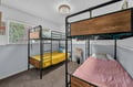 Your group will rest easy in this cozy bunk room with colorful linens and natural light streaming through the window. Perfect for families or friends traveling together.