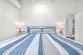 Drift into peaceful sleep in your coastal-inspired bedroom, where soft blue linens and warm bedside lighting create the perfect retreat.
