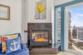 Cozy up by your crackling fireplace while enjoying ocean views from this charming nautical-themed living space.
