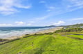 The property sits steps from this pristine stretch of golden sand, where rolling waves meet miles of untouched coastline framed by lush coastal greenery.