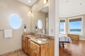 Refresh in your spacious en-suite bathroom with dual sinks and warm wood finishes, then step into your bedroom where ocean waves stretch to the horizon through floor-to-ceiling windows.