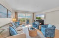 Sink into coastal comfort with ocean views stretching beyond your private balcony, where blue hues and warm firelight create your perfect seaside retreat.