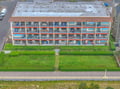 Multi-story vacation property with individual balconies and spacious lawn areas visible from above.