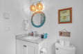 Your coastal bathroom features warm woven pendant lights, elegant marble vanity, and charming nautical touches that make every moment feel special.