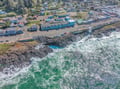 Dramatic coastal town perched above rocky shores where emerald waters crash against rugged cliffs, creating nature's spectacular show.