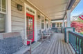 Relax on your private covered porch with comfortable seating, perfect for morning coffee or evening conversations in this charming neighborhood setting.