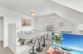 Unwind in your bright studio space with a fully equipped kitchen, breakfast bar, and entertainment area perfect for relaxing after beach adventures.