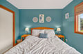 Drift off in your coastal-themed bedroom with calming blue walls and comfortable linens for a peaceful night's rest.