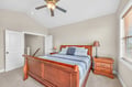 Rest peacefully in this cozy bedroom featuring a beautiful wood sleigh bed, matching nightstand, and gentle ceiling fan for your comfort.