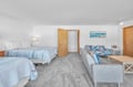Your spacious studio welcomes you with two comfortable beds, a cozy seating area, and calming ocean-inspired decor for the perfect coastal retreat.