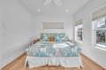 Drift into peaceful sleep in your bright, coastal-themed bedroom with ocean-inspired linens and gentle natural light streaming through your windows.